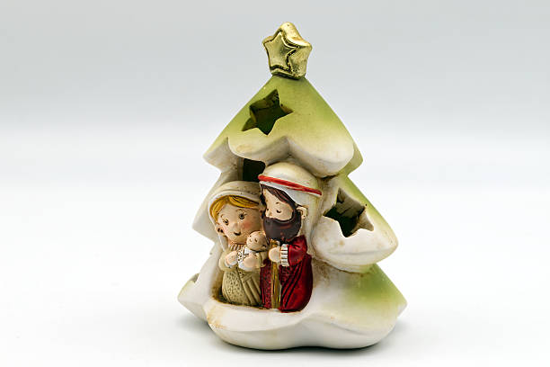 Three multi ethnic wisemen figurines  Christmas tree and fireplace background  Selective focus on kneeling wiseman. 