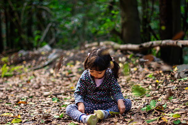 A pretty Indian girl child and long hair posing smiling outdoors with tree