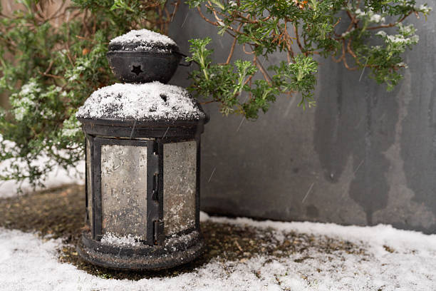 istock A warm glow emanates from a black lantern during a gentle snowfall 2255184696
