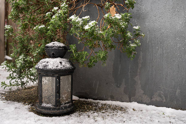 istock A warm glow emanates from a black lantern during a gentle snowfall 2255184716