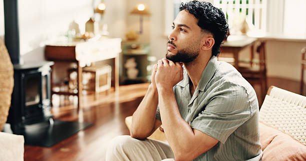 istock Home, thinking and man on sofa, choice and contemplation with decision, calm and thoughtful. Rest, problem solving and person on couch, nostalgia and planning for daily activity, solution and memory 2255187769