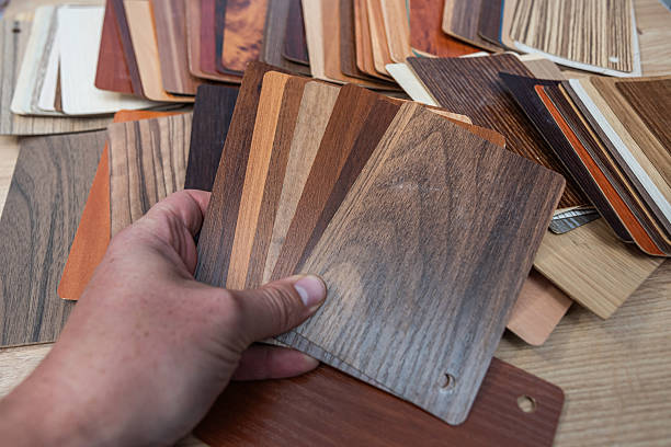 istock Hand choosing from an array of wood and laminate flooring samples for home design. 2255188012