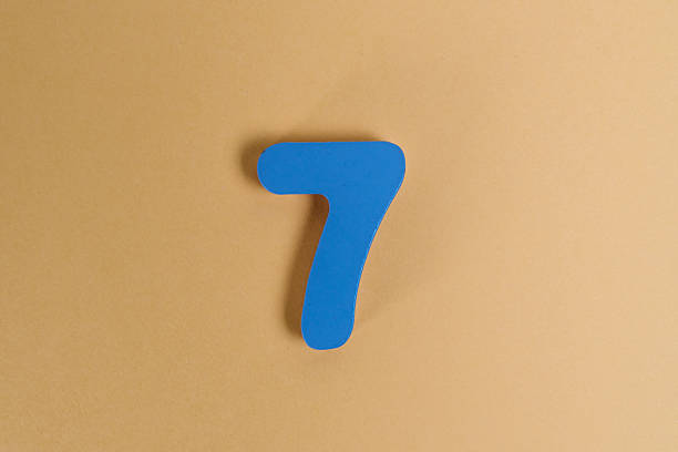 Blue number seven wooden toy on a beige background representing early childhood education