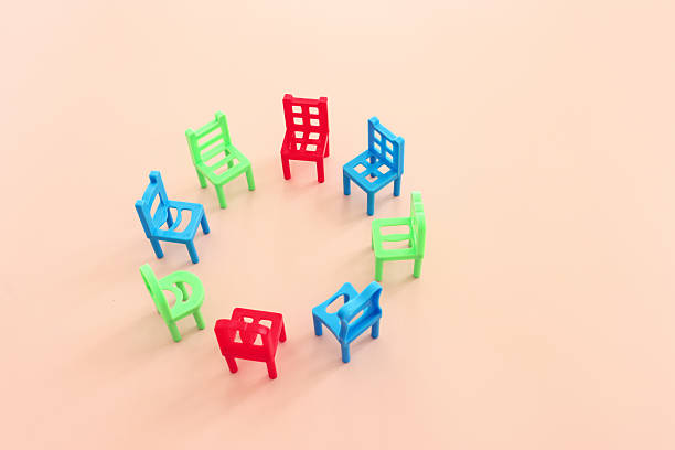 A 3D render concept of a group of chairs in a circular formation symbolizing a group therapy in session on an isolated white studio background