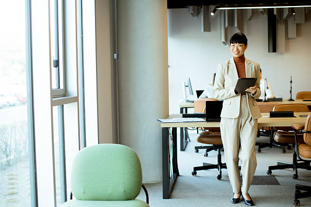 istock Business professional walks in modern office carrying tablet during work hours 2255189386