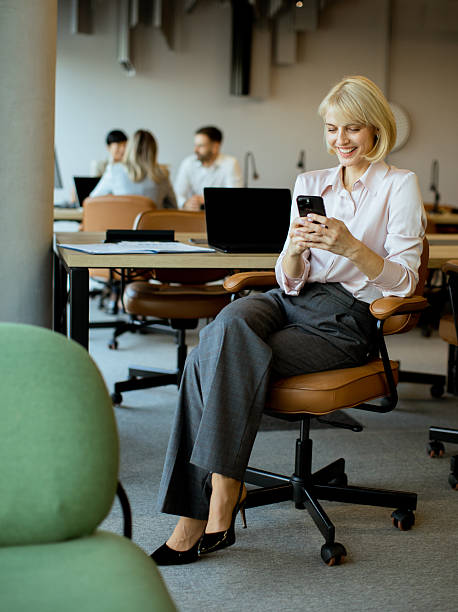 istock Professional woman engaging with her smartphone inside a modern office 2255189992