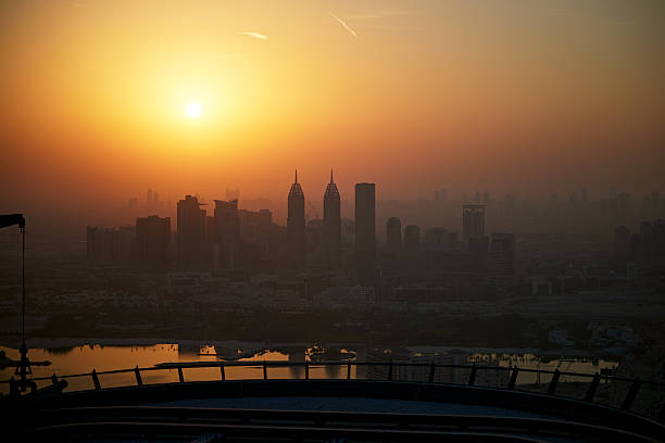 Dubai cityscape with skyscrapers reflecting orange light in the morning.