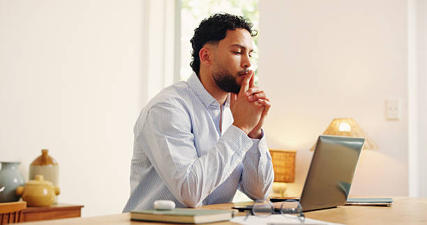 istock Laptop, reading and thinking with business man in home office for problem solving or research. Computer, planning and remote work with freelance employee at desk in apartment for startup ideas 2255191424