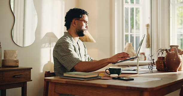 istock Typing, man and research with laptop, home and creative for logo design on web or freelance project. Graphic designer, online and person with tech for digital art, technical skills and remote work 2255193572