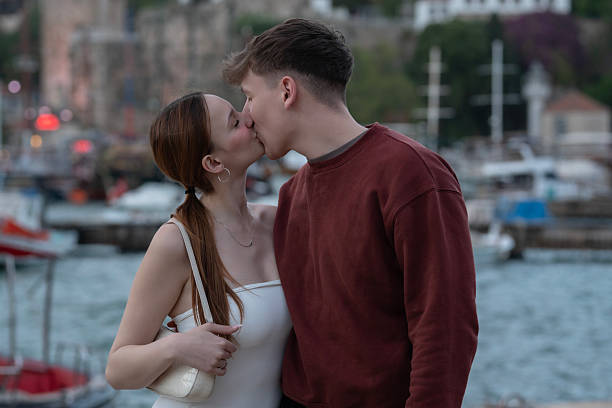 Romantic couple sharing a tender moment in a park, enjoying the warm glow of the setting sun