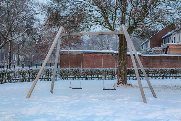 A picture of a swing set at the playground in a suburb of Den Bosch (s'-Hertogenbosch) covered in snow after rare, prolonged snowfall in the Netherlands in January of 2026.