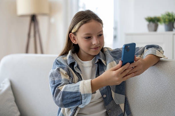 istock Young Girl Using Smartphone at Home on Sofa 2255195324