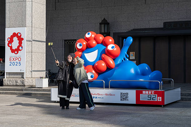 Osaka, Japan - January 11, 2025 : People take a selfie with Myaku-Myaku, the mascot representing 2025 World Expo, at Osaka City Hall in Osaka, Japan.