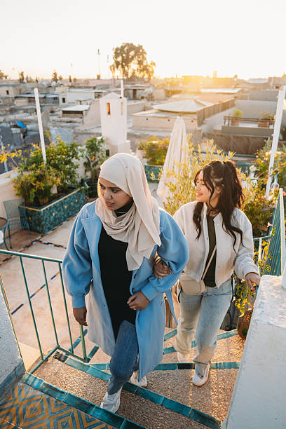 Two young adult women walking down rooftop stairs