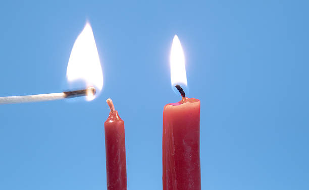 Small red candle waiting to be lit up in order to become a big red burning candle