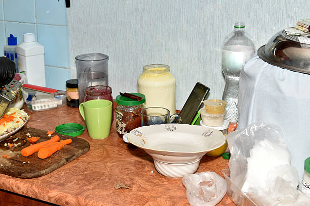 There are dishes and carrots on the kitchen table.