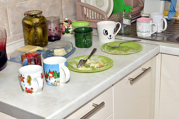 There are dishes on the kitchen table near the sink.