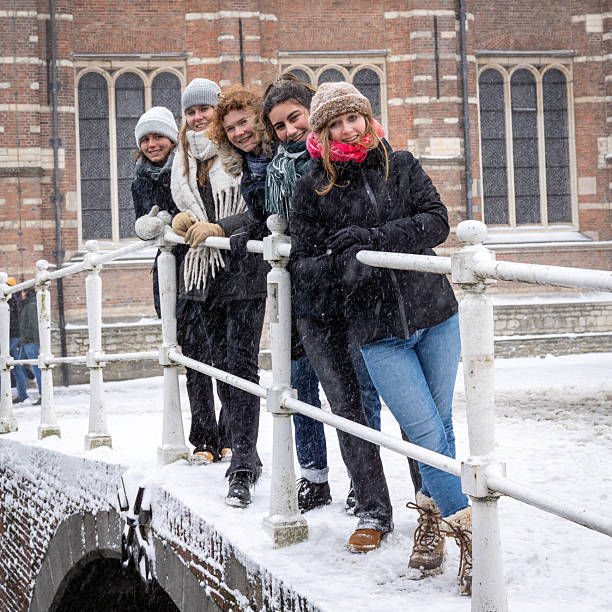Female students stand on the bridge of the academy building of Leiden University in the snow