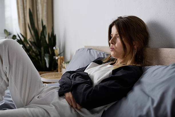 istock Young woman embracing bed rotting in a cozy modern apartment setting 2255207344