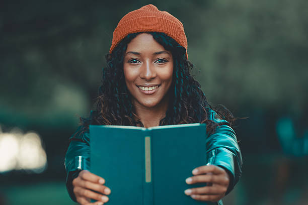 istock young woman with hat in autumn smiling with a book 2255209818