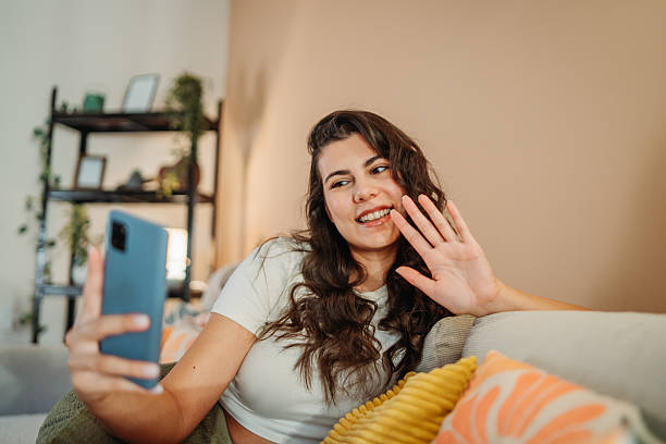 istock Woman making video call waving hand at home 2255210595