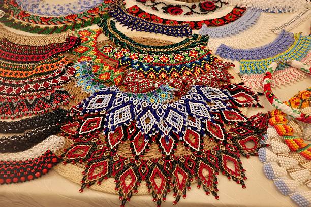 A vibrant collection of handmade beaded necklaces and collars featuring geometric and floral motifs in rich colors. These artisanal pieces highlight ethnic craftsmanship and are ideal for cultural branding, jewelry marketing, social media visuals, and folk-inspired web design.