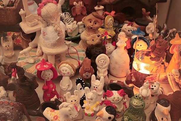 A playful collection of handcrafted ceramic figurines featuring animals, people in costumes, and fantasy characters, illuminated by a warm candle glow. Rich in detail and personality, this artistic display is ideal for creative branding, craft market visuals, social media storytelling, and handmade product promotion.