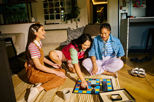 Three young women enjoying an offline board game night together in a cozy living room