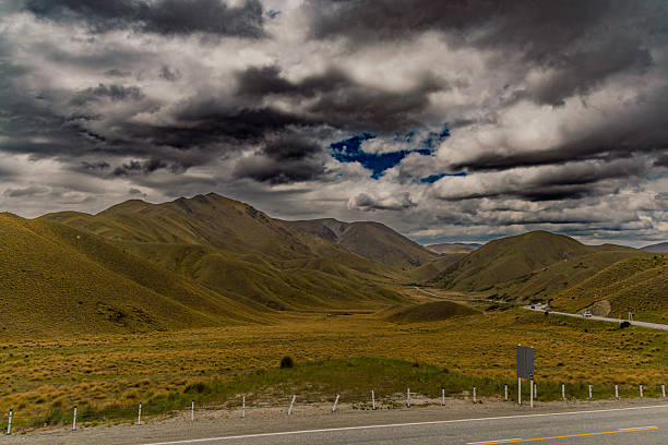 Brooding weather looms over remote grassy hills dramatic sky moody overcast dark