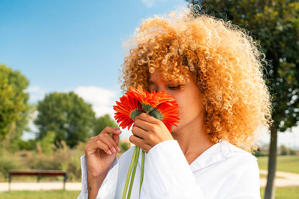 Colorful soft tenderness flowers in voluminous bouquet in a hands of a girl who goes on a city street