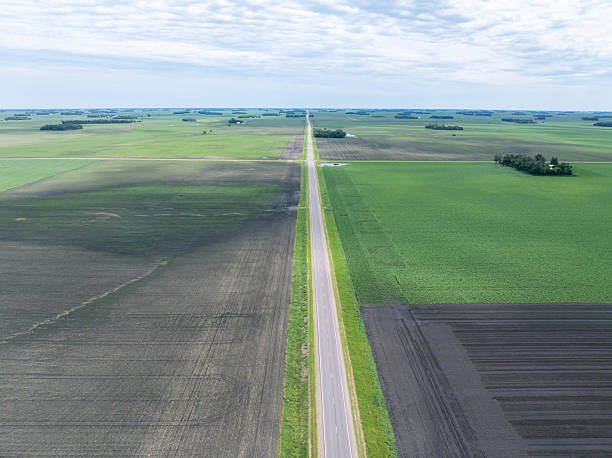 istock Endless Straight Highway Through Vast Agricultural Fields in the Great Plains 2255229226