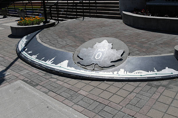 St. John's, Newfoundland and Labrador, Canada: a unique traffic sign, the official Kilometer Zero marker of the Trans-Canada Highway in St. John's, Newfoundland. Authorized by the Trans-Canada Highway Act of 1949 and fully completed in 1971, this 7,821-kilometer roadway is one of the world's longest national highways. The marker features a maple leaf and a silhouette skyline illustrating the route from the Atlantic to the Pacific, symbolizing the engineering feat that unites all ten Canadian provinces. As the eastern terminus, this site marks the beginning of a vital artery for national commerce and tourism.