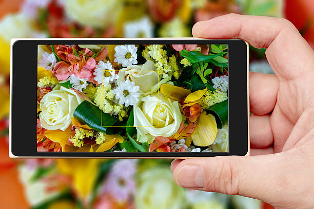 Flowers beautiful bouquet on smartphone screen. Decorative floral natural background.
