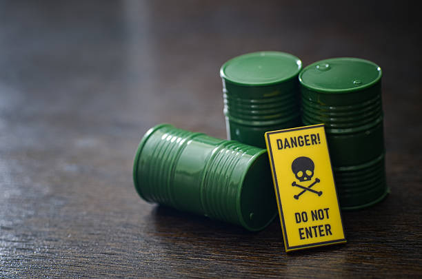Conceptual toxic waste storage illustrated with small barrels and danger warning