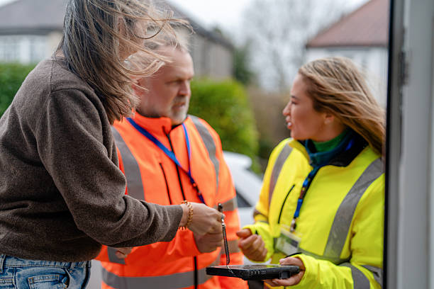 istock Workers discuss delivery details at a residential location while a woman signs a document 2255237155