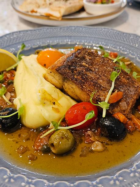Fish Steak on Mashed Potatoes with Decorative Vegetables and Olive