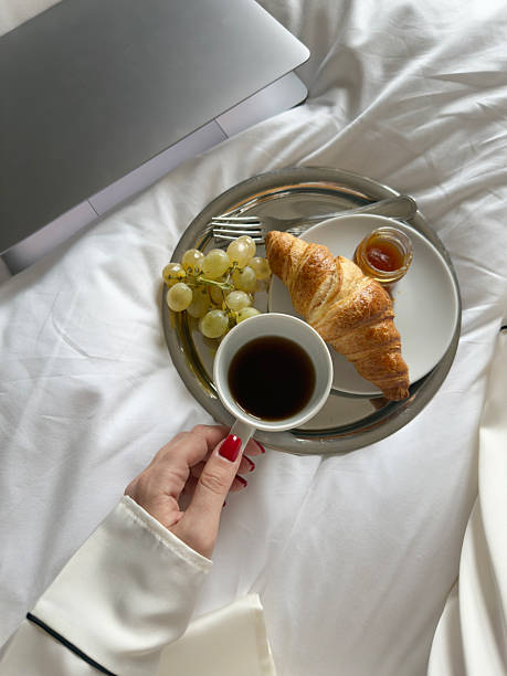 istock Enjoying breakfast in bed with laptop and white sheets 2255253596