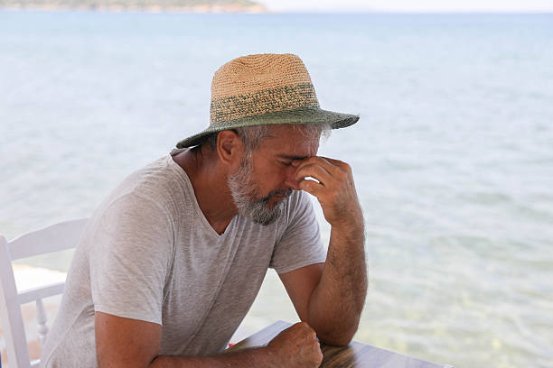 istock Stressed Middle Aged Man Sitting By The Sea 2255256417
