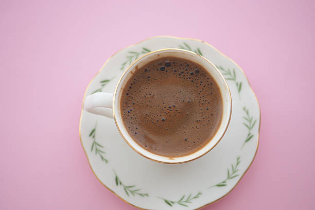 istock Warm coffee cup on delicate plate with pink background 2255260180
