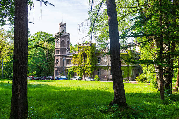 Kreuzlingen, Switzerland - September 24, 2014: A tourist strolls in the public park of the city of Kreuzlingen, a city in the canton of Thurgau in north-eastern Switzerland. At the edge of the park stands the Schloss Seeburg, a castle dating back to the sixteenth century, declared a Swiss heritage site of national significance and now hosting a restaurant. 