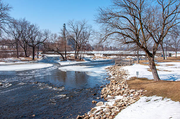 The open and unfrozen water of the White River as it flows beneath the Echo Lake dam in Burlington, Wisconsin.