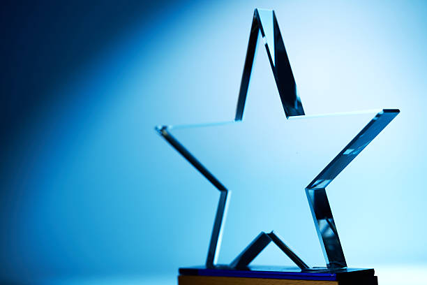 istock Crystal star shape trophy against blue background 2255264293