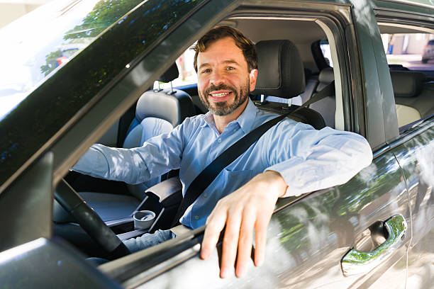 istock Latin man driving car, looking at camera, having a safe pleasant journey. Commuting, traveling, or driving for leisure 2255266041