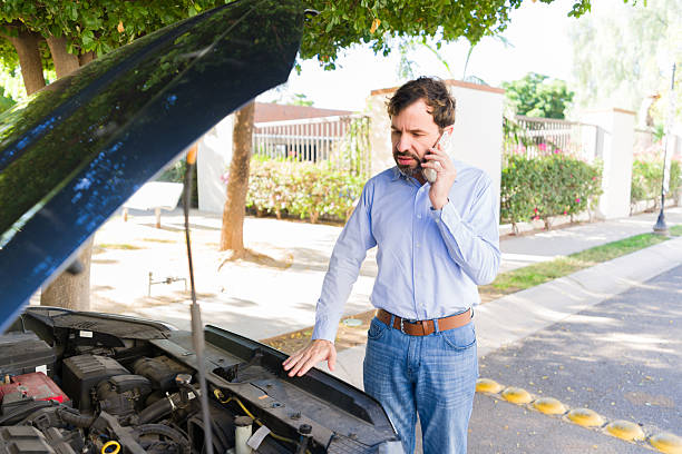 istock Worried man talking on phone needing assistance with broken down car, engine trouble on roadside 2255266079