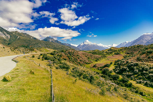 Sunny countryside shows curving route near peaks landscape nature travel