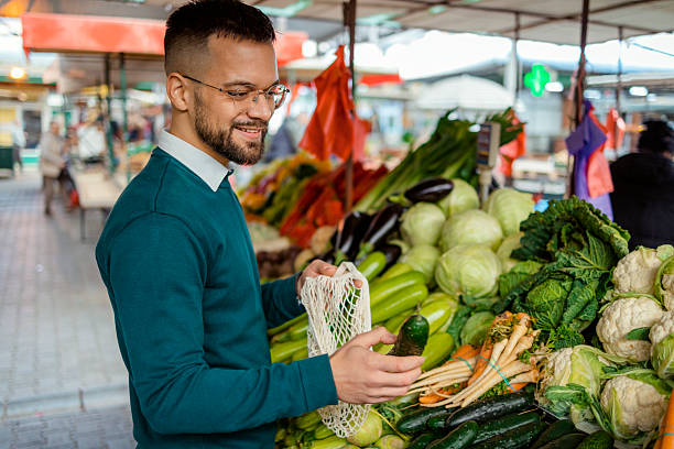 istock Man Using Reusable Mesh Bag at Urban Vegetable Market 2255268977