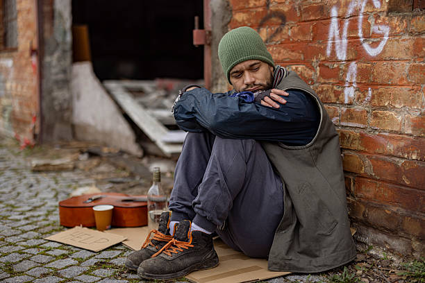 istock Homeless Man Sitting in Decayed Urban Environment 2255269041