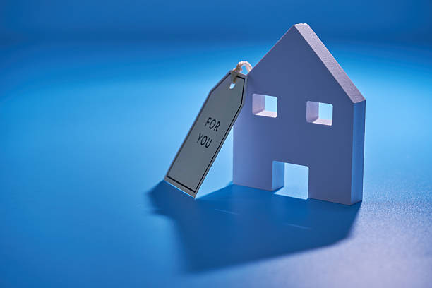 istock small  house model and  greeting tag  against blue background 2255270528