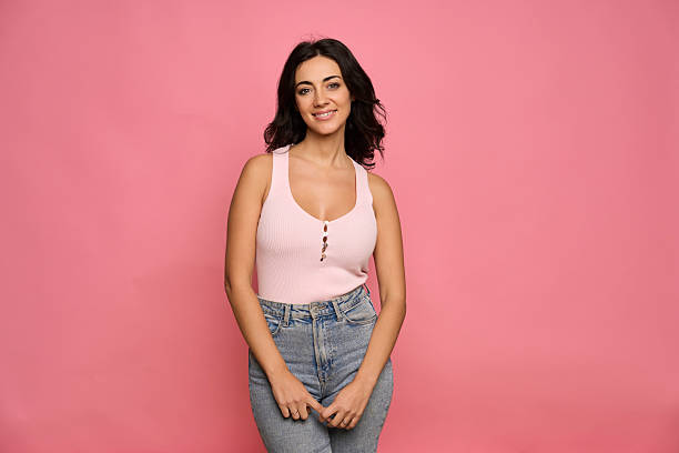 Young adult woman standing with a friendly smile, looking at the camera