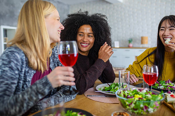 istock Three women enjoy a friendly meal at a dining table, laughing and bonding in a cozy home interior 2255276128
